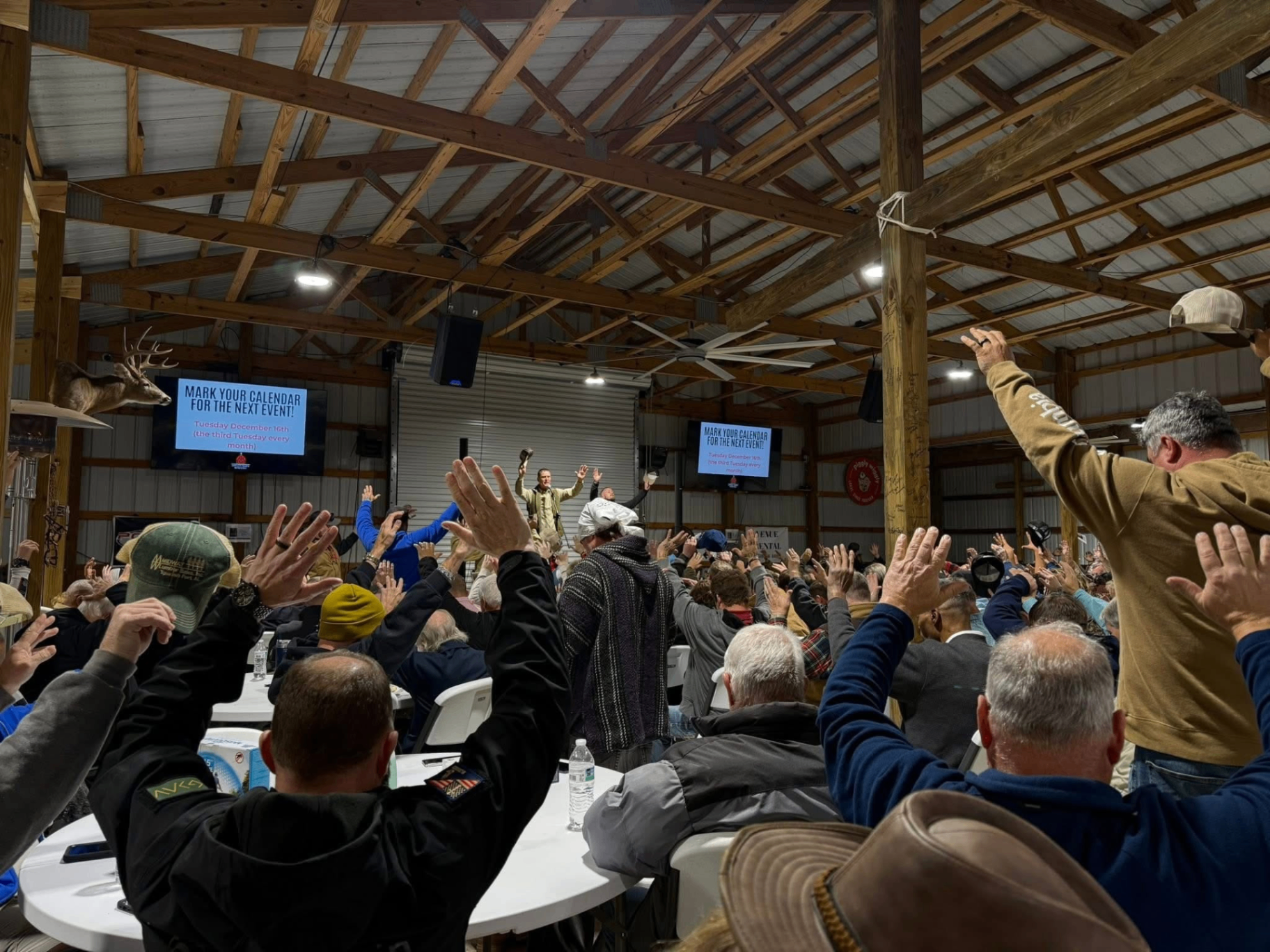 Men raising their hands in worship inside The Loxley Barn